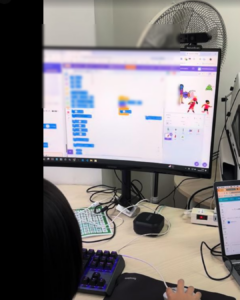 子どもがパソコンの前で手を動かしながら課題に取り組む様子