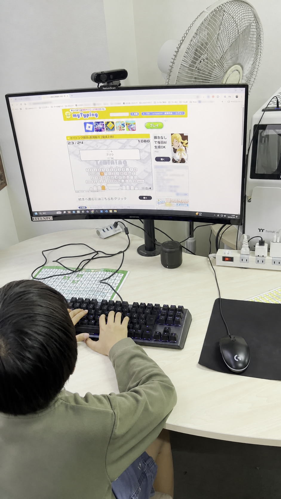 パソコンの前でキーボードを操作する後ろ姿