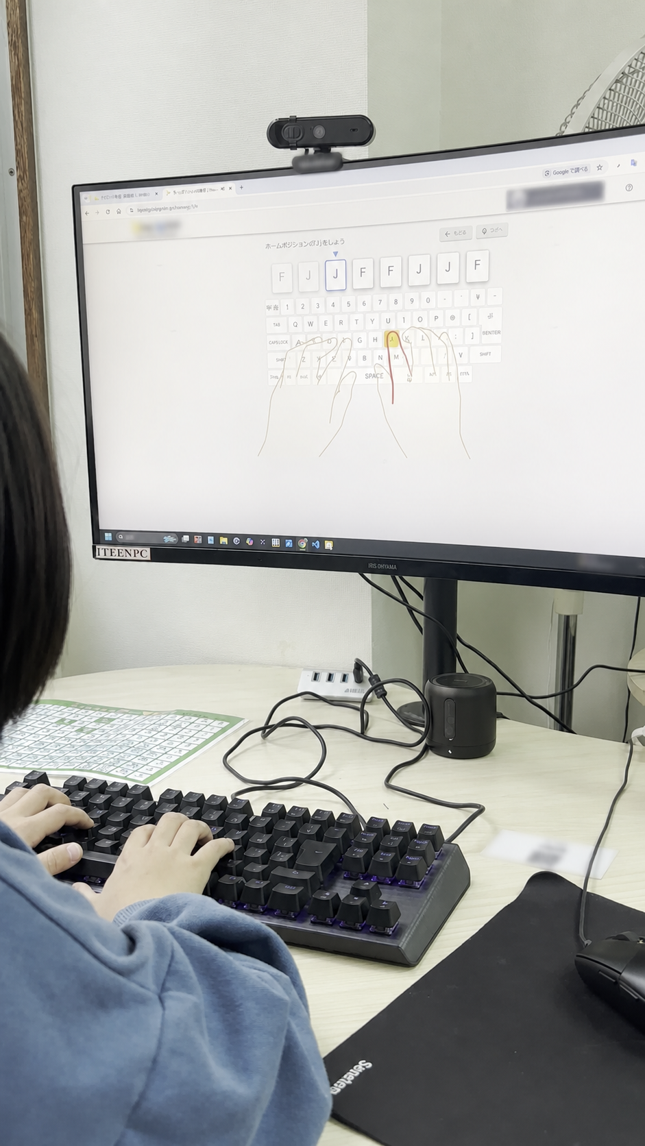 キーボードを操作しながら画面を確認する後ろ姿