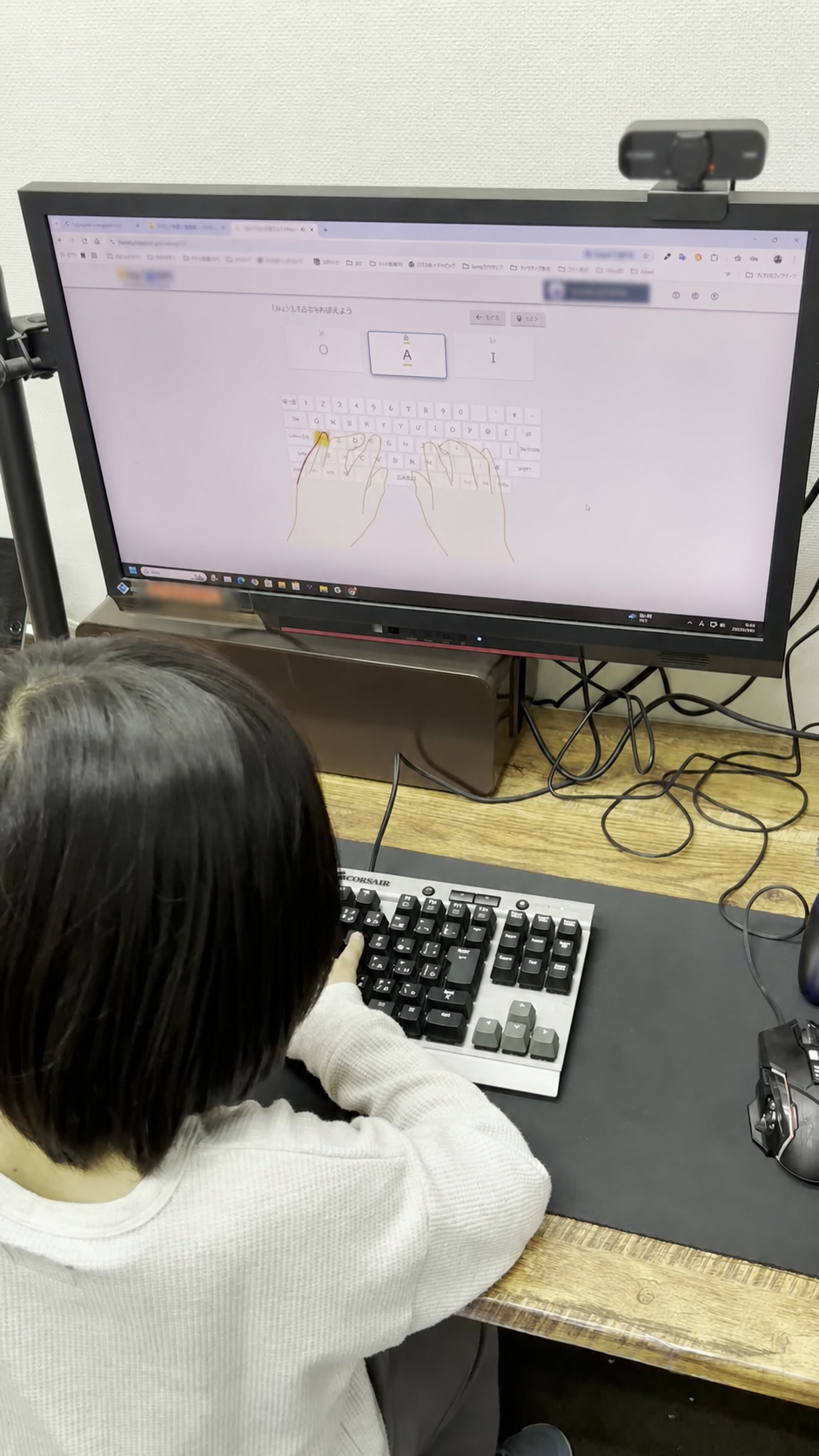 キーボードを操作しながら画面を確認する後ろ姿