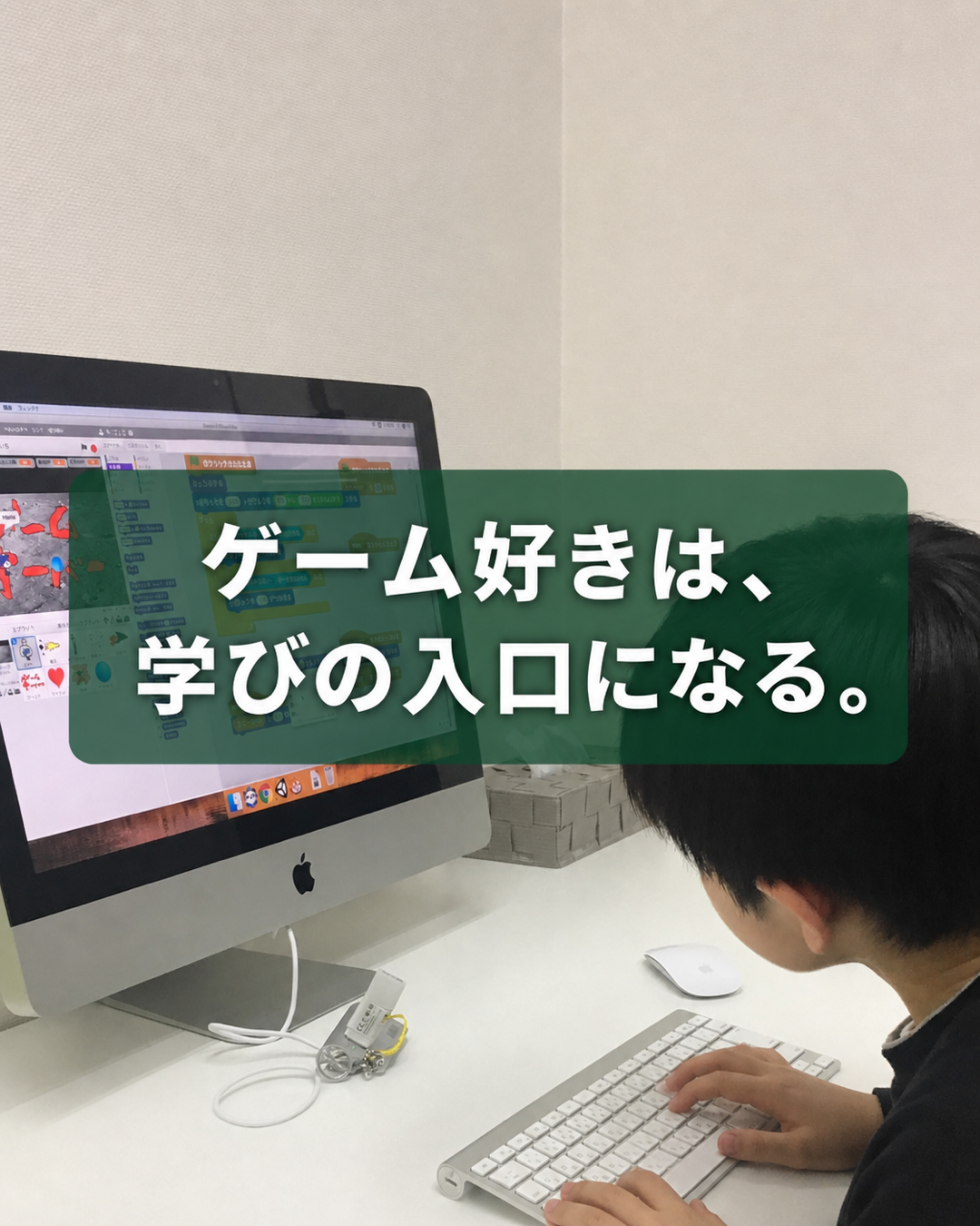 子どもがScratch作品を操作する後ろ姿。中央に「ゲーム好きは、学びの入口になる。」の文字。