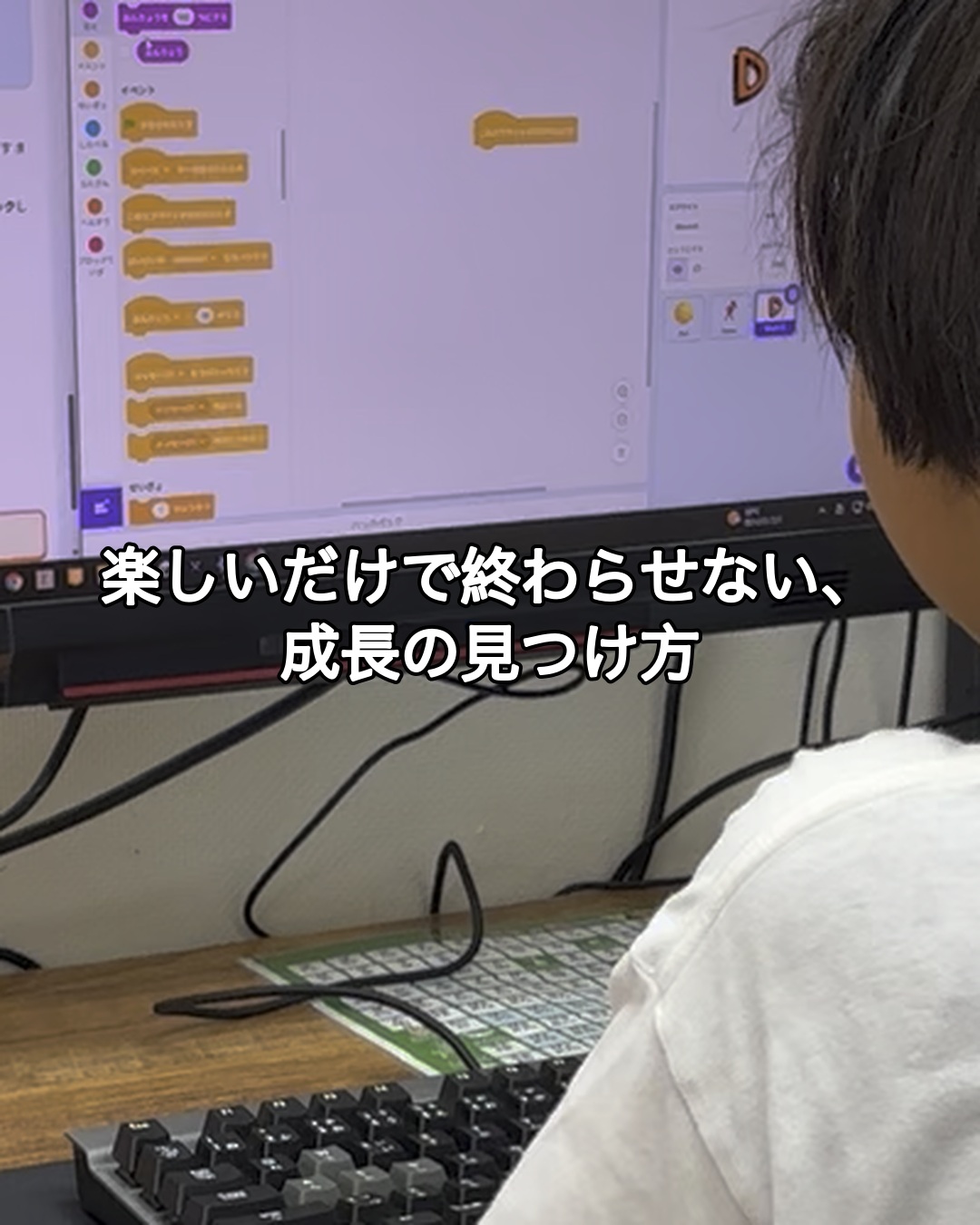 後ろ姿の小学生がScratchの作品づくりに取り組む学習風景